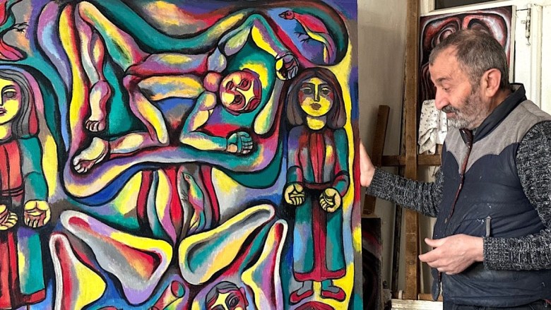 Arnold Meliksetyan stands alongside one of his newest creations，“Mulberry Leaf Pickers” (2024) (photo Siranush Sargsyan/Hyperallergic)