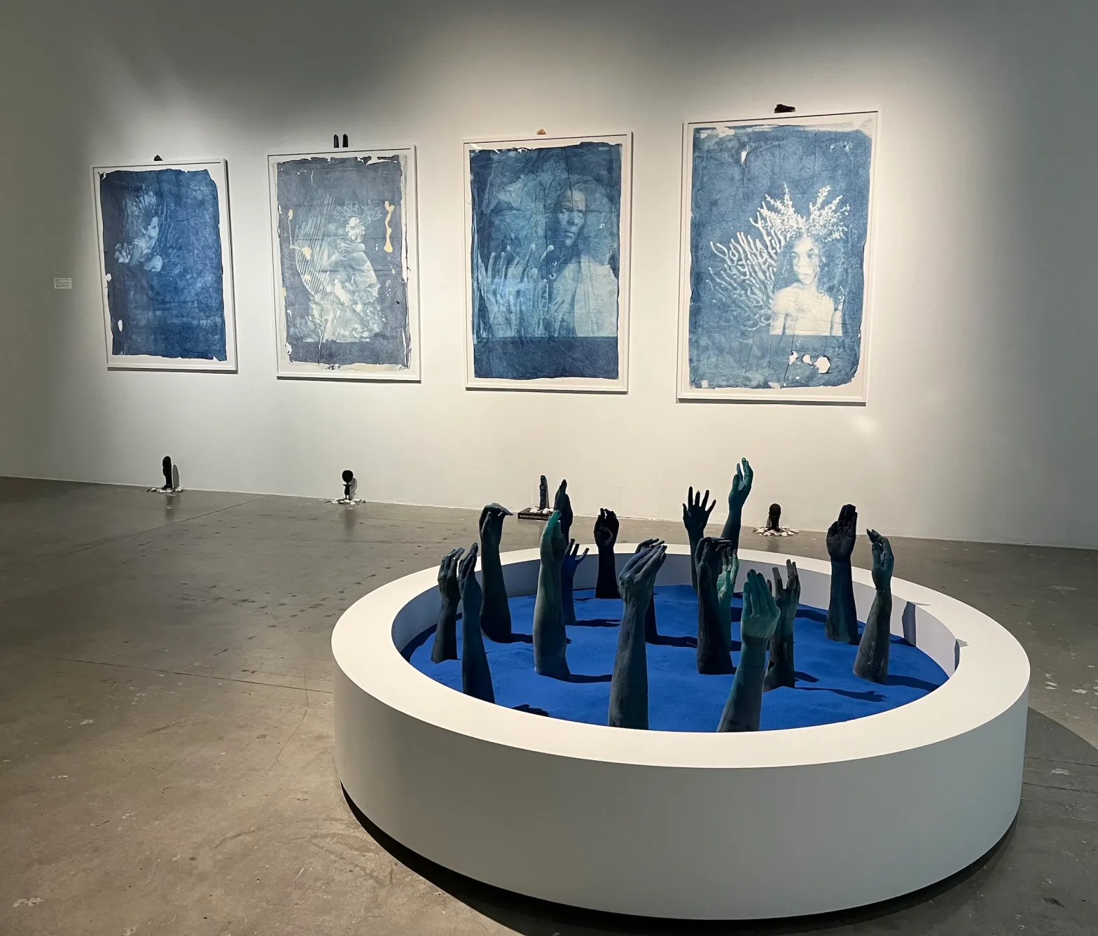 Hands reach out from Drexciya in Andrea Chung’s Between Too Late and Too Early (photo Francess Archer Dunbar/Hyperallergic)