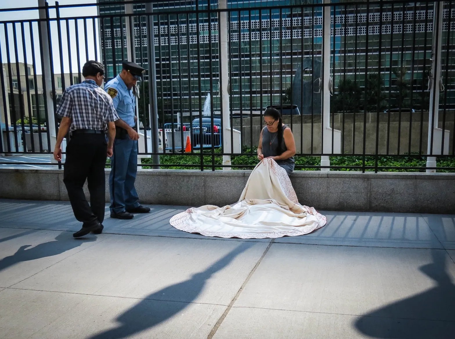Security guards ask Elina Chauvet to stop her “Confianza” (2013–) performance and leave the United Nations Headquarters grounds.