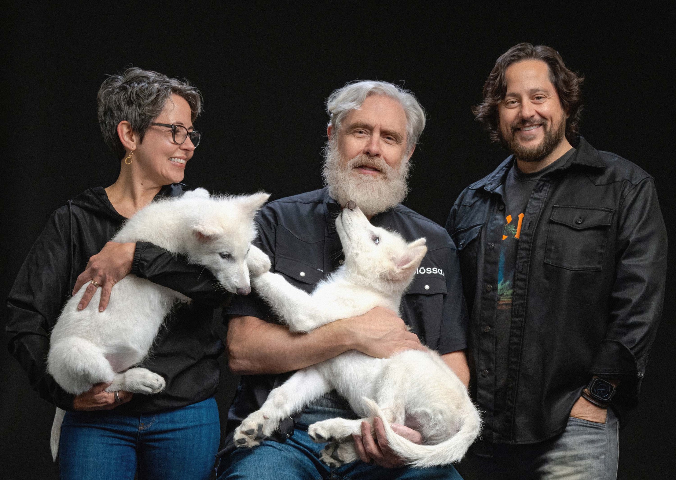 From left to right: Beth Shapiro, George Church, and Ben Lamm pose with the pups.