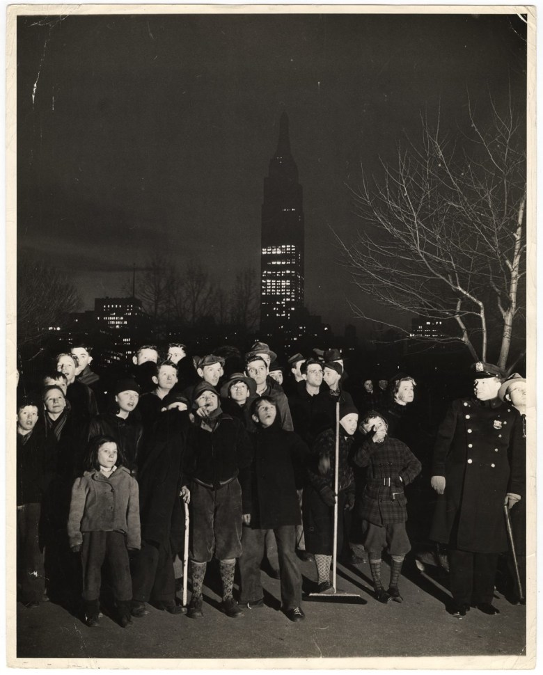 Weegee, “Night… a black velvet curtain has dropped over the white sky… a few mothers went looking for their kids… found them here… dragged them home for supper… but they are back again… but that’s the same Empire State Building in the Background….,” (1944), photograph