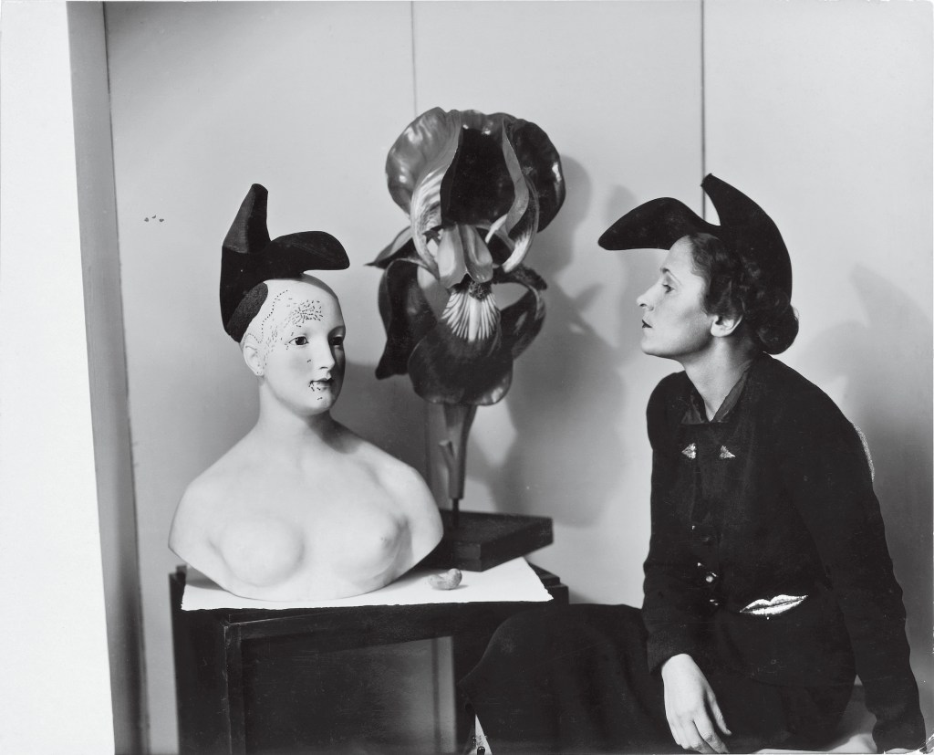 Gala Dalí wearing the “Shoe Hat” and “Lips Jacket，” which she inspired. They were designed by Schiaparelli in collaboration with Salvador Dalí in 1938. (© Salvador Dalí，Fundació Gala–Salvador Dalí，Figueres; photo by André Caillet)