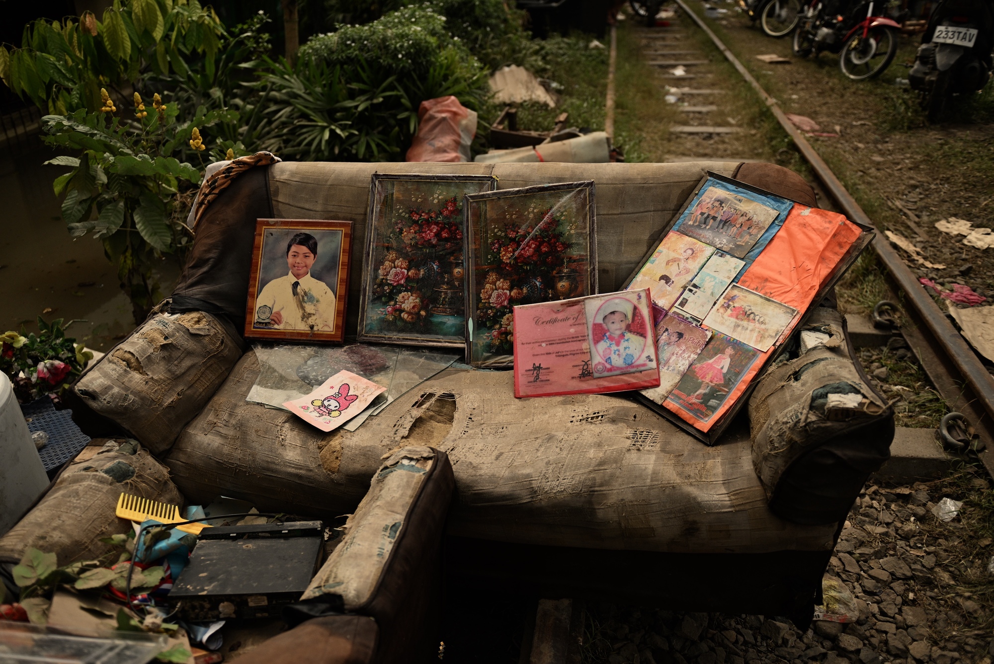 2024年10月25日，菲律賓北部那牙市（Naga City），潭美颱風過後，人們在沙發上晾乾家庭和畢業照片。（攝影／Noel Celis／AP Photos）