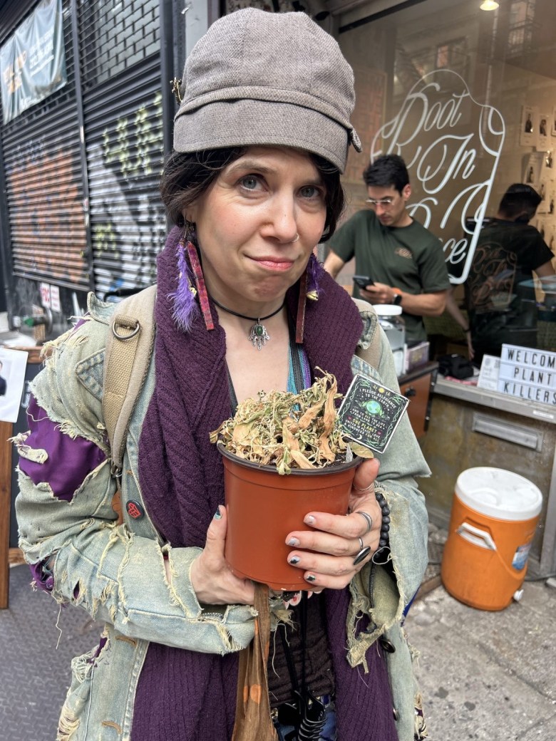 Samm Cohen poses with her plant that she brought to the funeral.