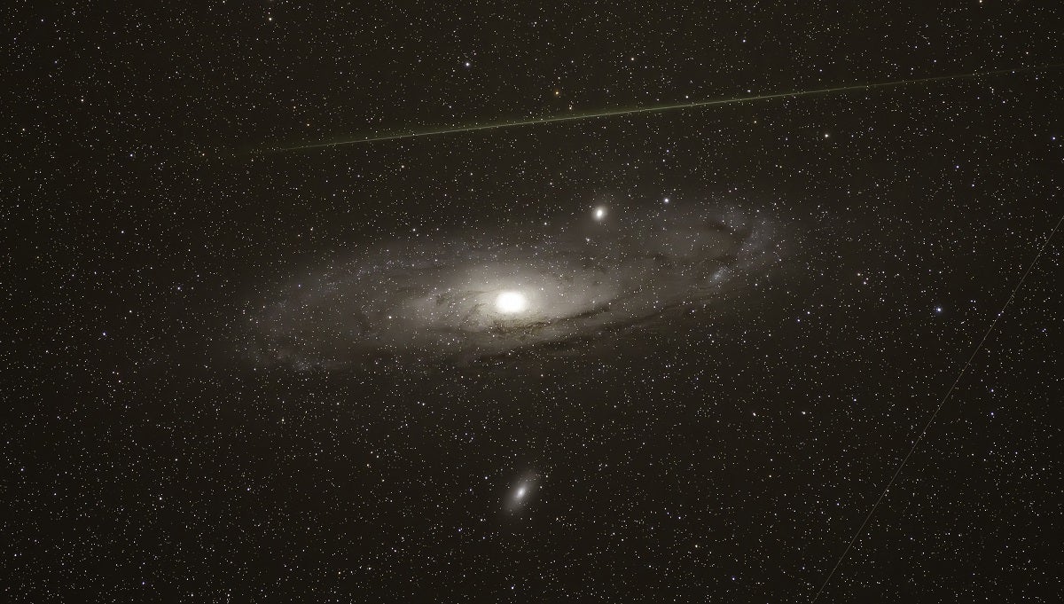 Like how the Earth keeps the Moon bound on a gravitational tether, our nearest galactic neighbor, the Andromeda galaxy (M31), is surrounded by a bunch of tiny satellite galaxies.